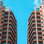 Contemporary high-rise buildings contrasted against a vivid blue sky, showcasing modern urban architecture.